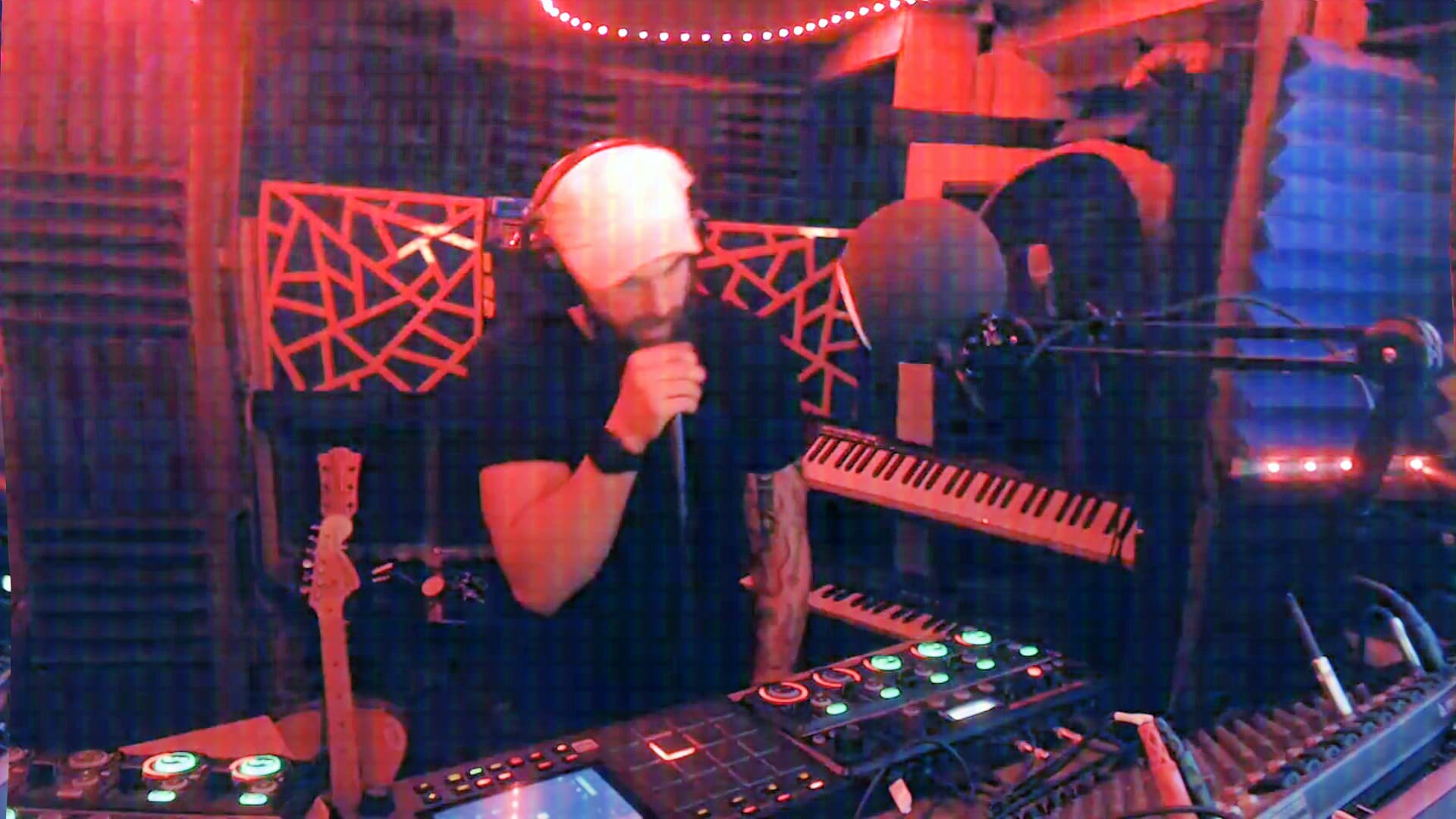 VØBØRNY working with electronic music equipment in colorful stage lighting